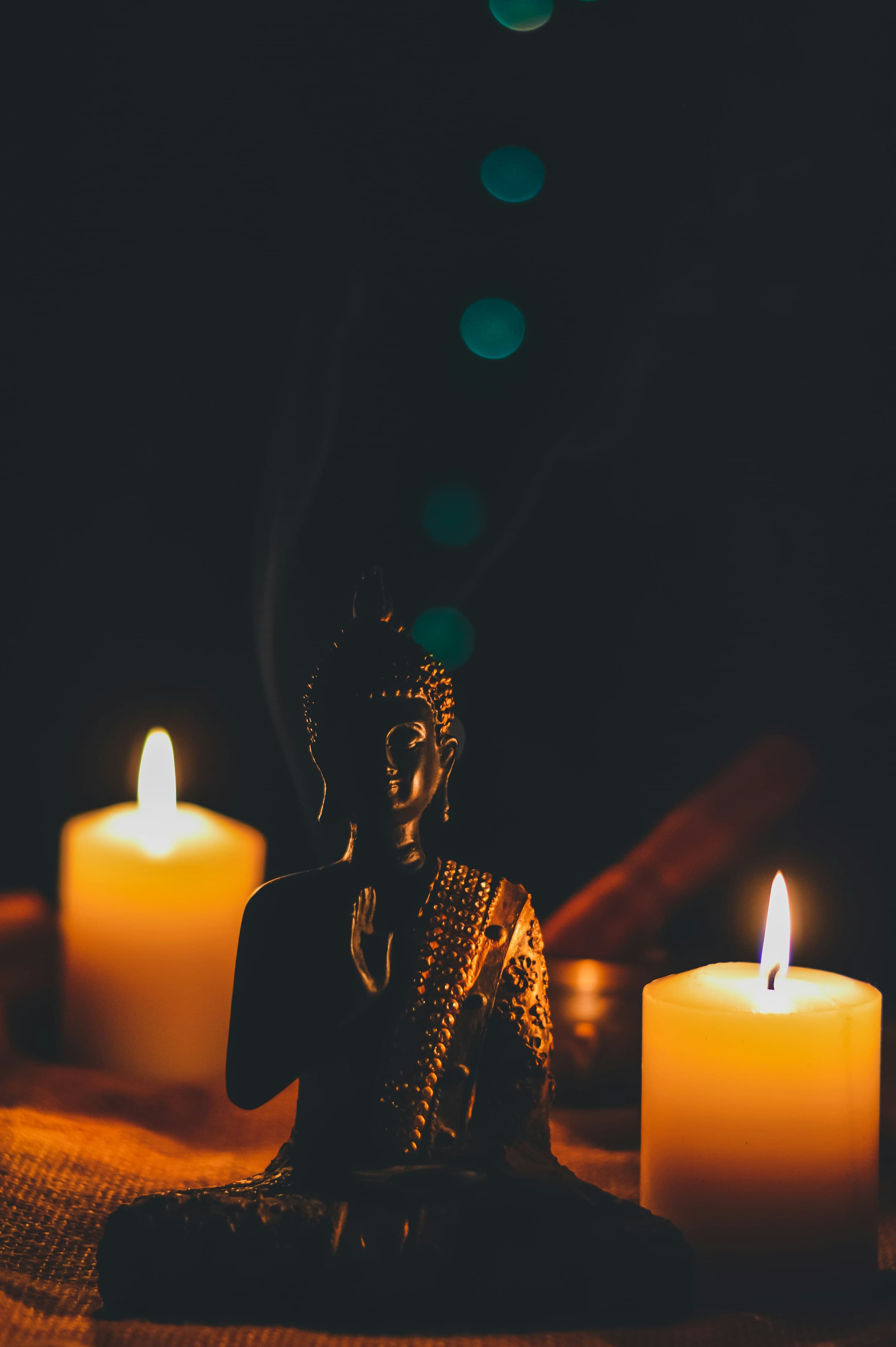 A candlelit Buddha statue — the quiet, grounded feeling Align Aura brings to every conversation